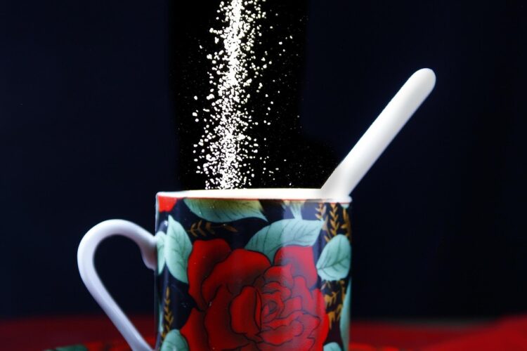 Sugar being poured into a mug